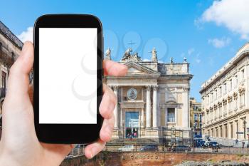 travel concept - tourist photograph Anfiteatro Romano and Church San Biagio in Piazza Stesicoro in Catania, Sicily, Italy on smartphone with cut out screen with blank place for advertising logo