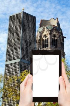 travel concept - tourist photograph Kaiser Wilhelm Memorial Church in Berlin, Germany on tablet pc with cut out screen with blank place for advertising logo