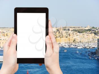travel concept - tourist photograph skyline of Valletta city in summer day, Malta on tablet pc with cut out screen with blank place for advertising logo