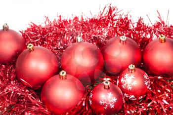 several red Christmas baubles and tinsel isolated on white background