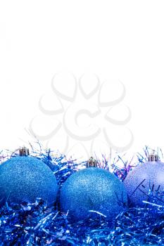 three blue Christmas balls at tinsel close up isolated on white background