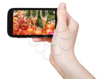 hand holds cellphone with Christmas still life on screen isolated on white background