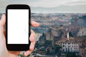 travel concept - hand holds smartphone with cut out screen and Coliseum in Rome on background