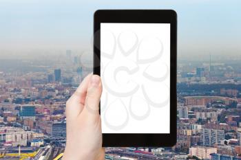 travel concept - hand holds tablet pc with cut out screen and urban landscape on background