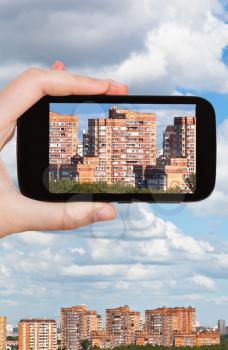 travel concept - tourist photographs picture of residential district on smartphone