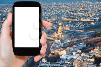 travel concept - hand holds smartphone with cut out screen and Paris cityscape on background