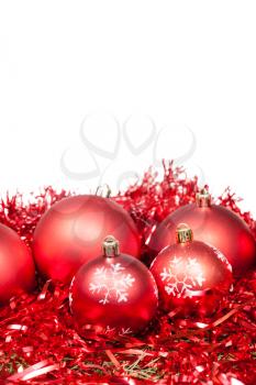 five red Christmas balls and tinsel isolated on white background