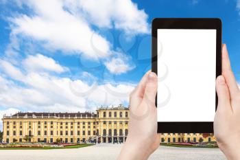 travel concept - tourist take photo of Schloss Schonbrunn palace in Vienna on tablet pc with cut out screen with blank place for advertising logo