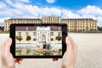travel concept - tourist take picture of fountain near Schloss Schonbrunn palace in Vienna on tablet pv