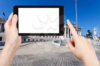 travel concept - tourist photographs Austrian Parliament Building in Vienna on tablet pc with cut out screen with blank place for advertising logo