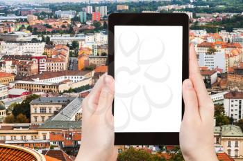 travel concept - tourist photographs Brno city skyline on tablet pc with cut out screen with blank place for advertising logo