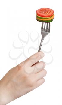 hand holding dinning fork with fresh sliced vegetables isolated on white background
