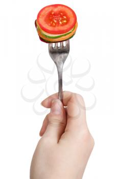 dinning fork with impaled fresh sliced vegetables in hand isolated on white background