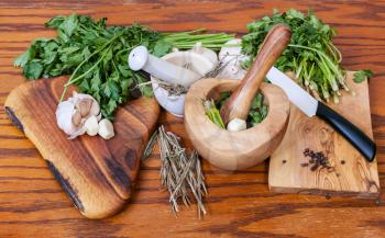 cooking seasonings - mortars and spicy herbs on wooden table