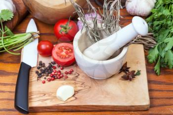 cooking seasonings - ceramic mortar and spicy ingredients on table
