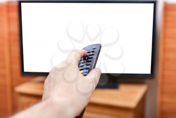 Hand switching channels on the TV with cut out screen by remote control in living room