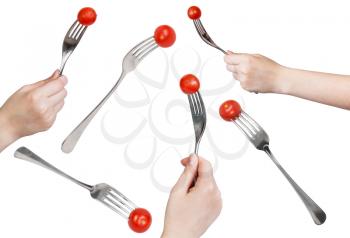 set of dinning forks with one fresh red cherry tomato isolated on white background