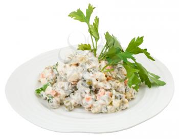 olivier russian salad with mayonnaise decorated with fresh greens on white plate isolated on white background