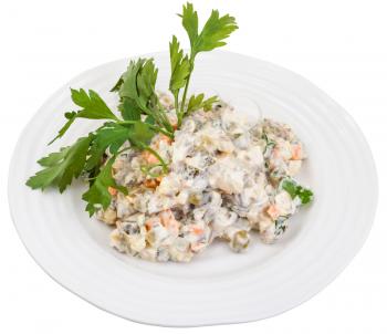 above view of olivier russian salad with mayonnaise decorated with green parsley on white plate isolated on white background