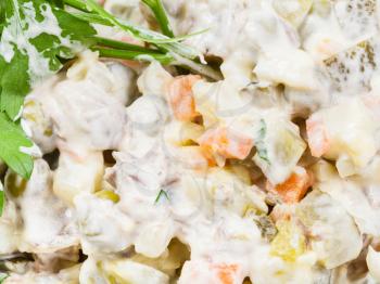 olivier russian salad with mayonnaise close up decorated with green parsley