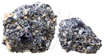 macro shooting of natural mineral stone - two pieces of Perovskite crystalline rock isolated on white background