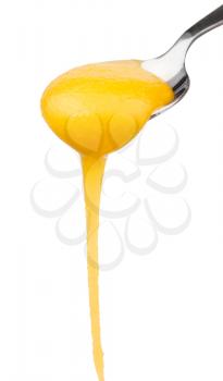 yellow dense honey flowing down from spoon close up isolated on white background