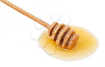puddle of clear honey and wooden spoon close up isolated on white background