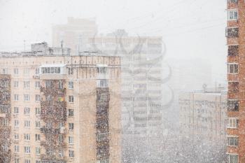 urban houses and snowfall in city in winter day