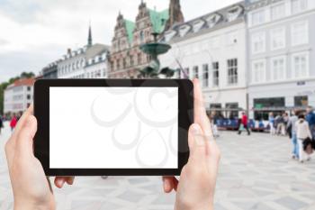 travel concept - tourist photographs Amagertorv the most central square in Copenhagen, Denmark on tablet pc with cut out screen with blank place for advertising