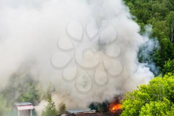 above view of fire and gray smoke in urban parking area in summer day