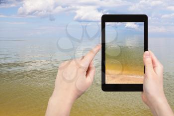travel concept - tourist photographs of calm surface of Azov Sea on tablet pc