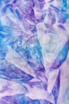 textile background - abstract blue and violet pattern on colored silk batik