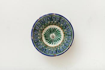 above view of typical central asian bowl on white plastering plate
