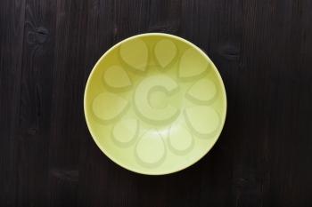 top view of one green bowl on dark brown table