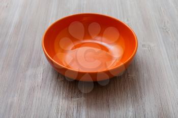 one orange bowl on gray brown board