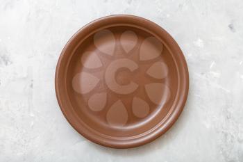 above view of one brown plate on gray concrete surface