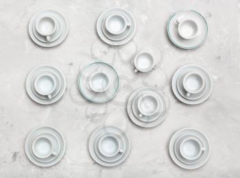 food concept - above view of many cups and saucers on gray concrete board