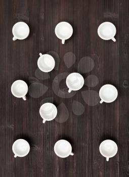 food concept - top view of many white cups on dark brown table
