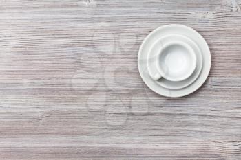 food concept - top view of one white cup with saucers on gray brown board