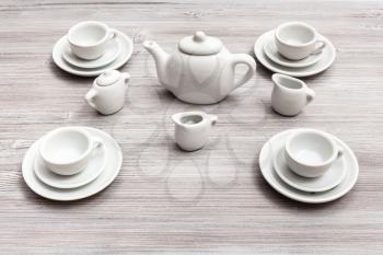 food concept - cups with saucers and tea set on gray brown table