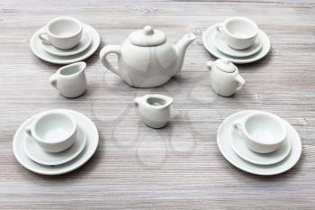 food concept - cups with saucers and tea set on gray brown board