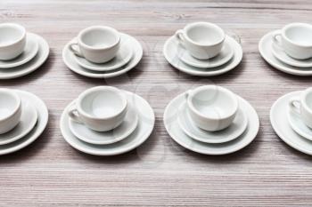 food concept - several white cups and saucers on gray brown table