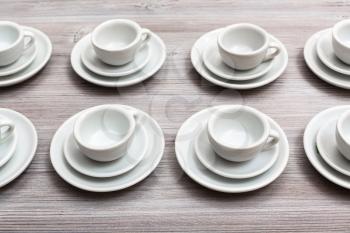 food concept - several white cups and saucers on gray brown board