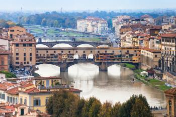 travel to Italy - above view of ponte vecchio (old bridge) on Arno River in Florence city from Piazzale Michelangelo in autumn evening