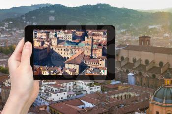 travel concept - tourist photographs center of Bologna city on tablet in Italy