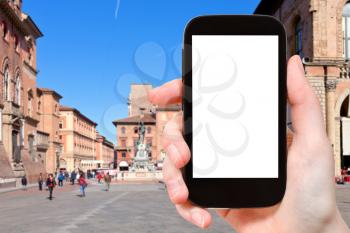 travel concept - tourist photographs square in Bologna city on smartphone with cut out screen with blank place for advertising in Italy