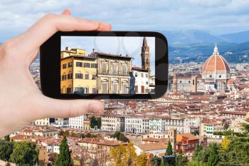 travel concept - tourist photographs houses in Florence city on smartphone in Italy