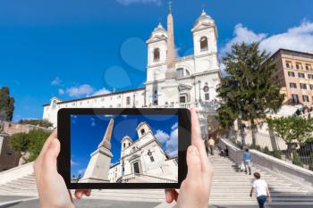 travel concept - tourist photographs Church Santissima Trinita dei Monti and Spanish Steps in Rome city on tablet in Italy