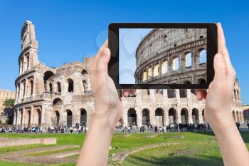 travel concept - tourist photographs Colosseum in Rome city on tablet in Italy