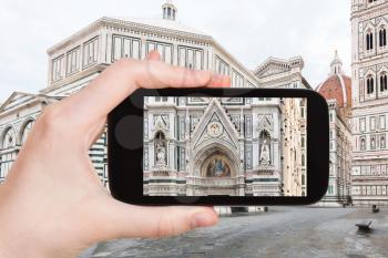 travel concept - tourist photographs decor of Duomo Santa Maria del Fiore in Florence city on smartphone in Italy